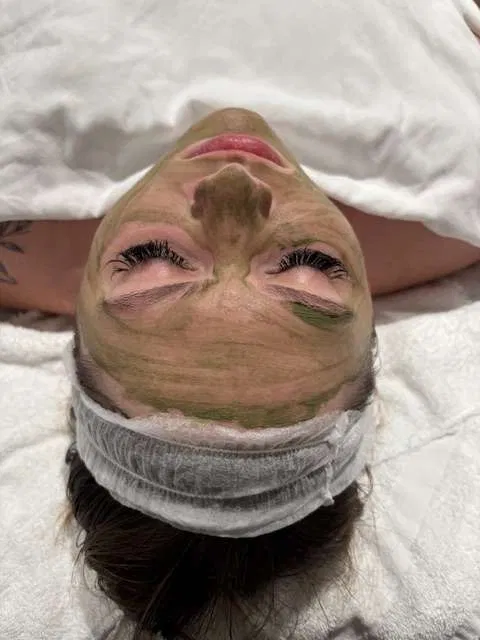 Green clay mask during a custom facial